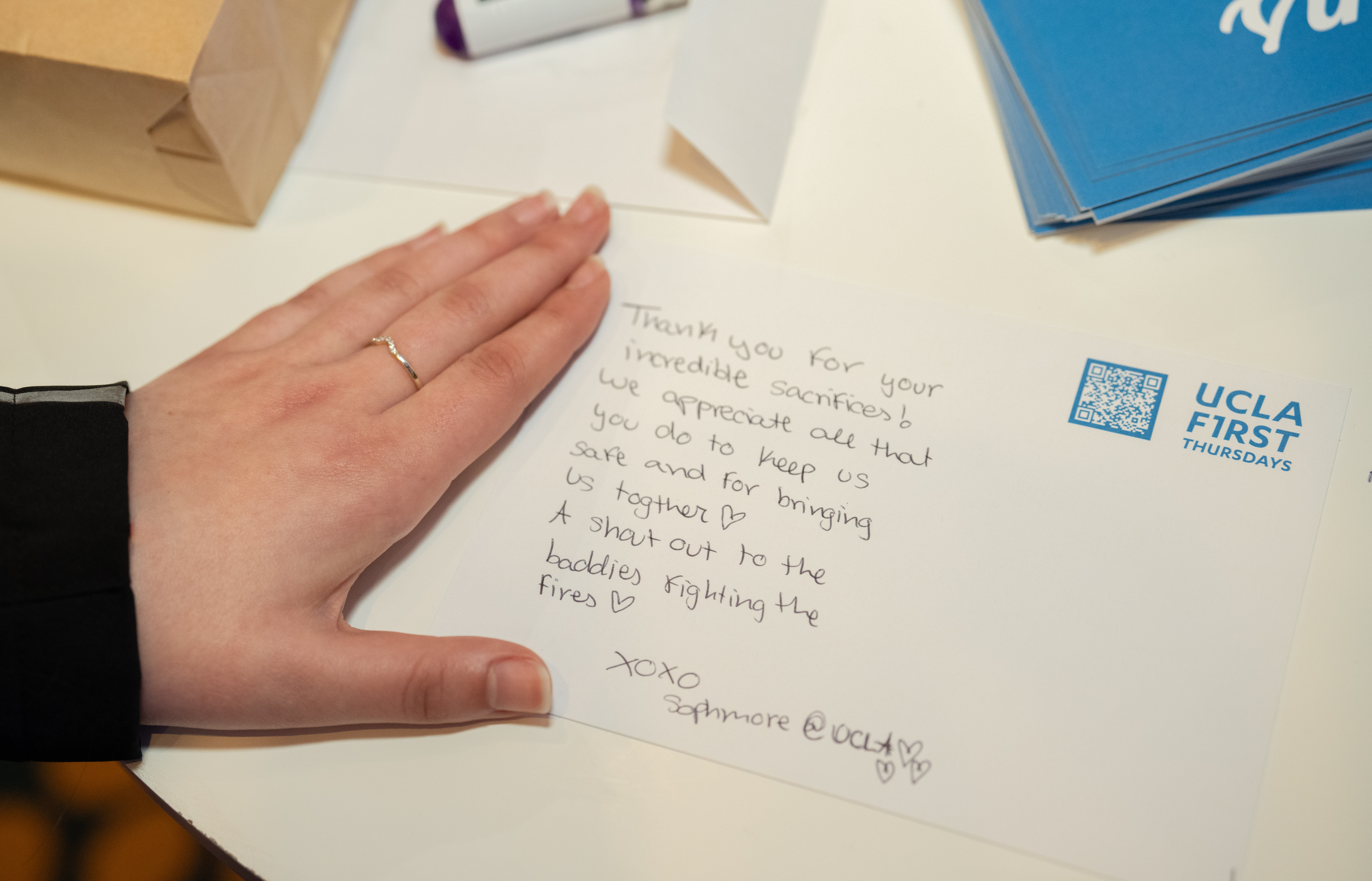 At First Thursdays, Bruins wrote thank-you cards for first responders and others involved in wildfire relief efforts. Close-up of hand on top of thank-you letter to first responders
