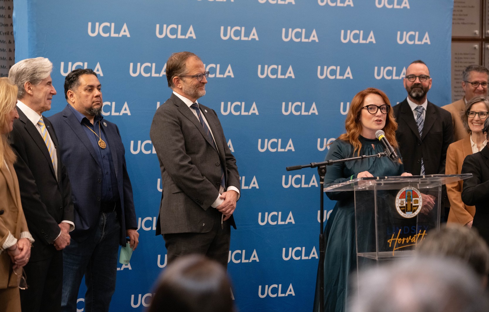 Chancellor Julio Frenk (far left) watches on as County Supervisor Lindsey Horvath announces an independent commission to inform wildfire recovery and rebuilding efforts. UCLA Chancellor Julio Frenk watches as County Supervisor Lindsey Horvath speaks at the podium
